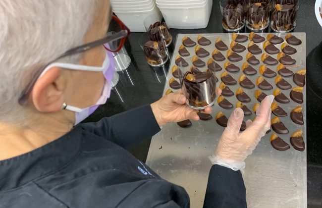 Claudie à la confection des chocolats orange ! Biscuitier Chocolatier Pâtissier